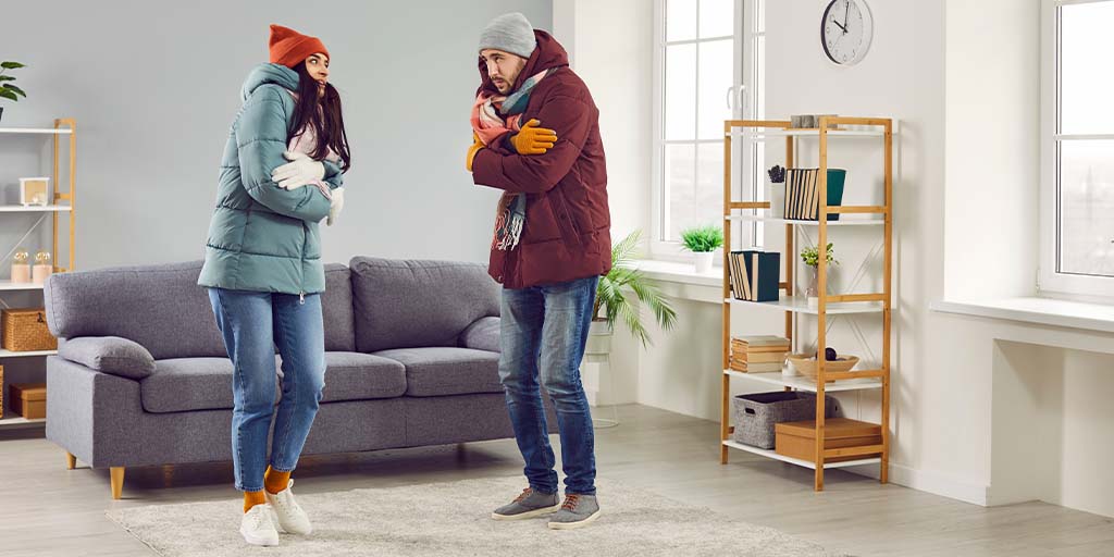 man and woman at home in winter keeping warm